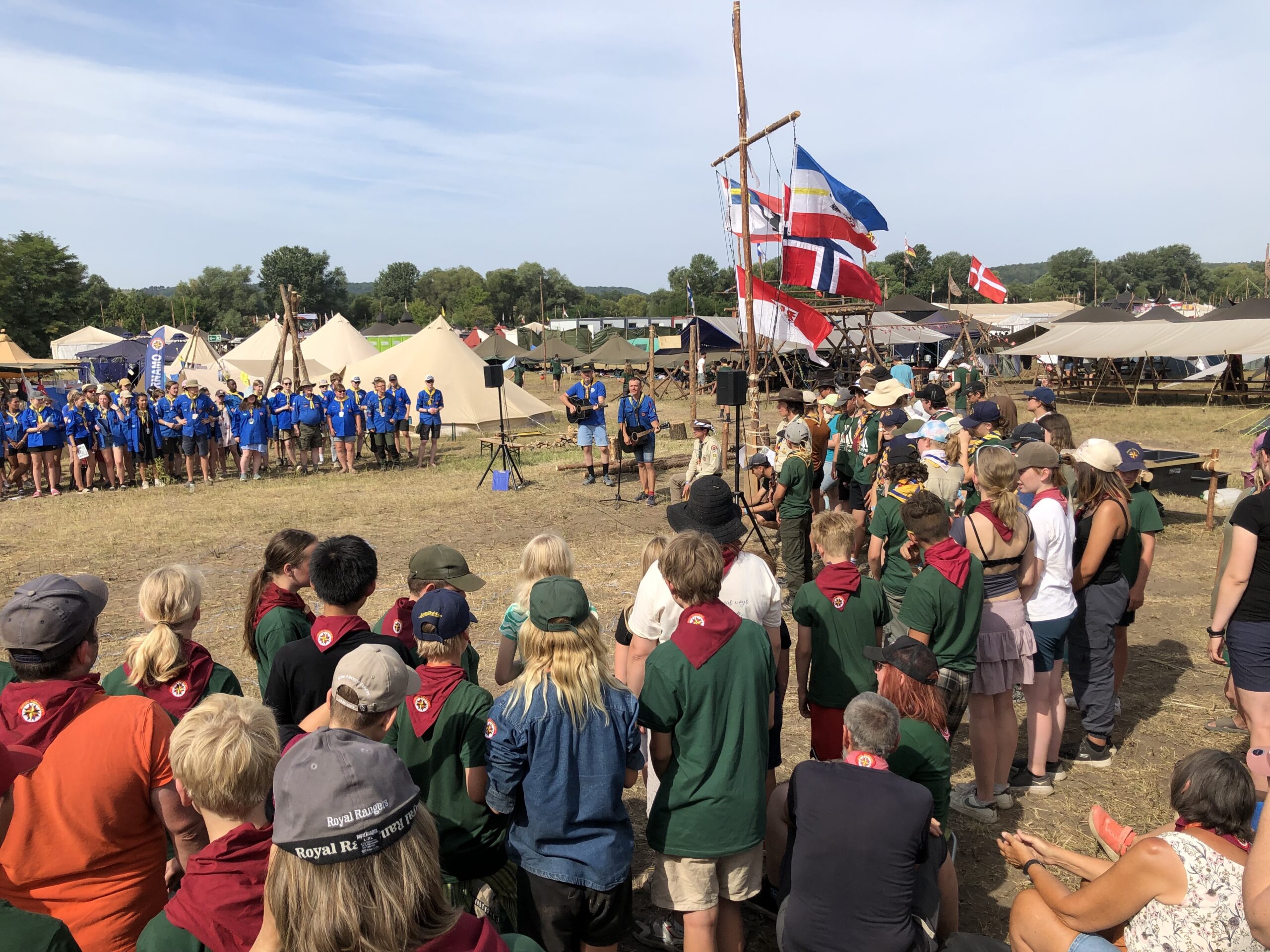 Speidere stående i en stor ring synger